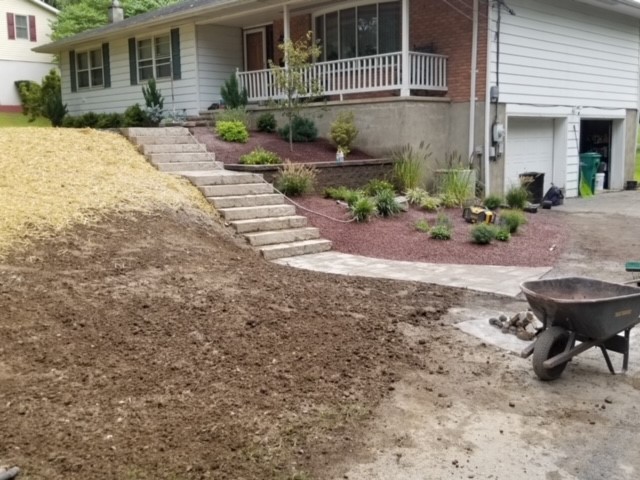 After House with over grown shrubs with a drive way now with nice steps